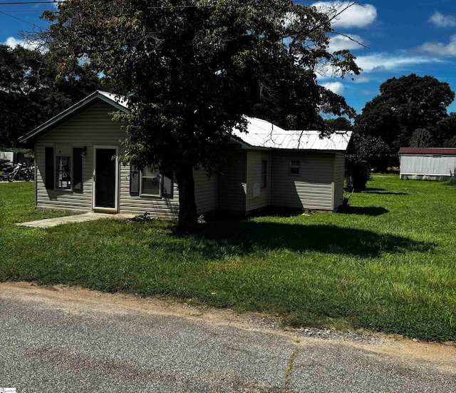 bungalow-style home featuring an outbuilding and a front yard