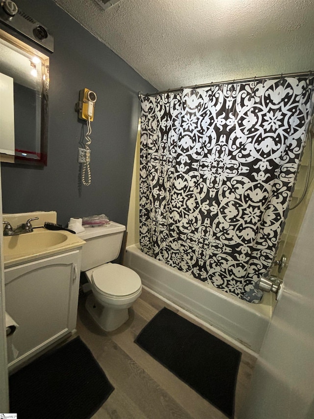 full bathroom featuring shower / bath combo, a textured ceiling, toilet, vanity, and wood-type flooring