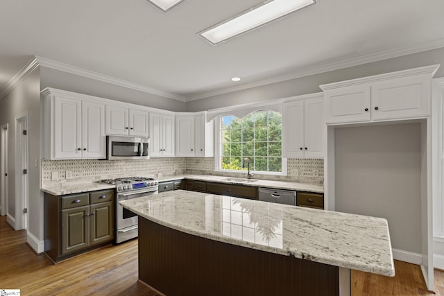 kitchen with stainless steel appliances, decorative backsplash, white cabinets, wood-type flooring, and ornamental molding