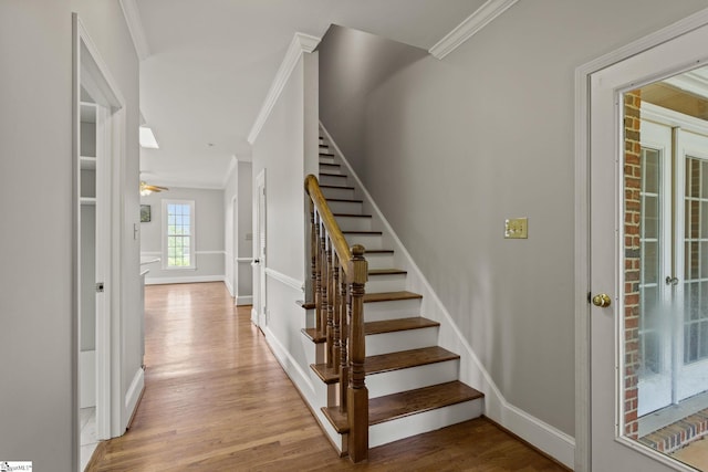 stairway featuring french doors, hardwood / wood-style floors, and crown molding