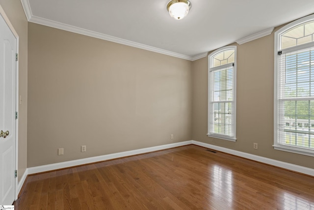 unfurnished room with wood-type flooring and ornamental molding