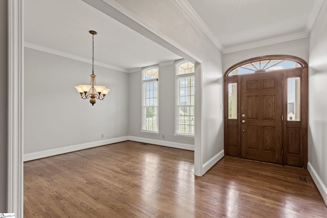 entryway featuring a notable chandelier, wood-type flooring, and ornamental molding