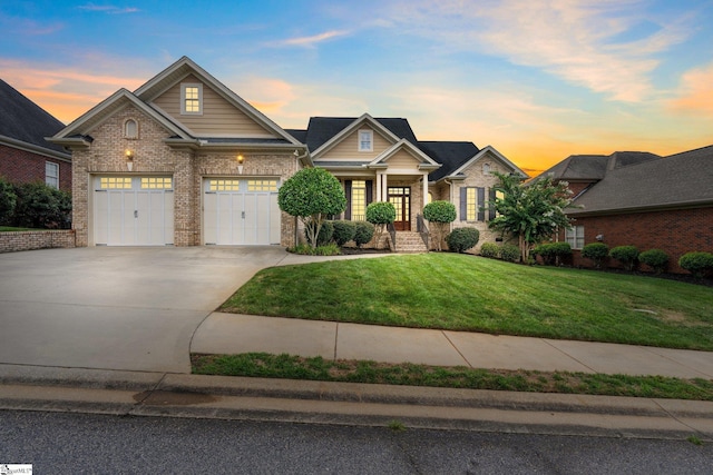 craftsman inspired home featuring a garage and a lawn