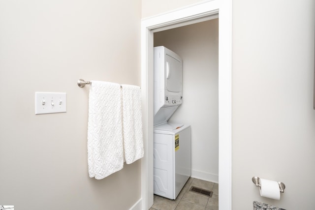 washroom with light tile patterned floors and stacked washer / dryer