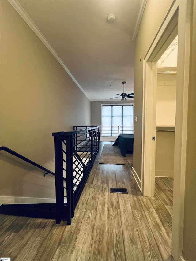 hall with ornamental molding and hardwood / wood-style floors