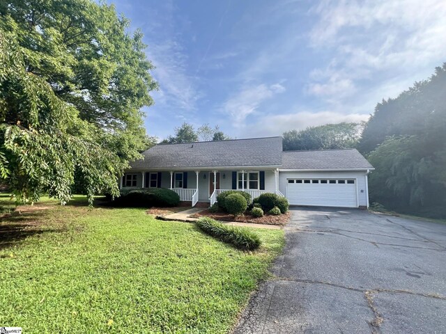 single story home featuring a garage and a porch