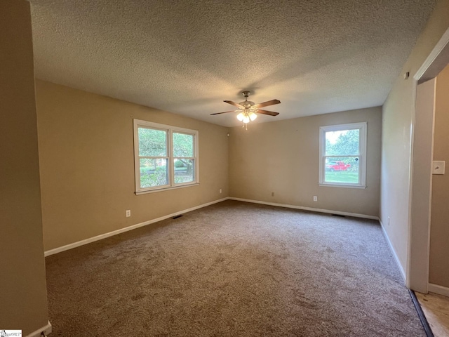 carpeted empty room with baseboards, a textured ceiling, and a ceiling fan