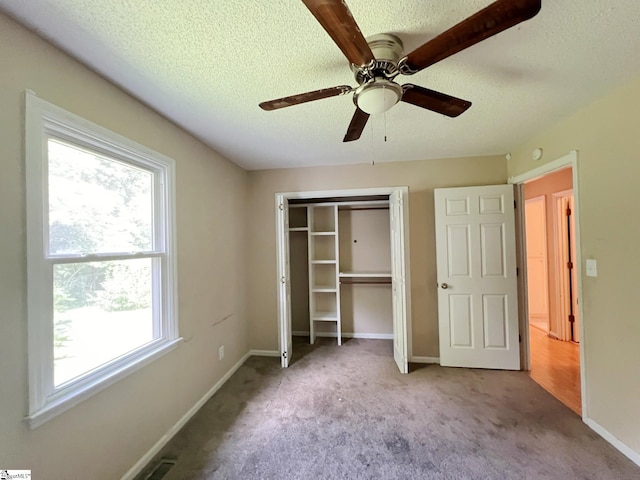 unfurnished bedroom featuring a closet, carpet floors, a textured ceiling, and baseboards