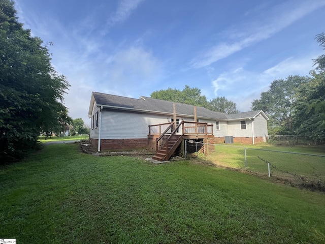 back of property featuring stairway, fence, a wooden deck, crawl space, and a lawn