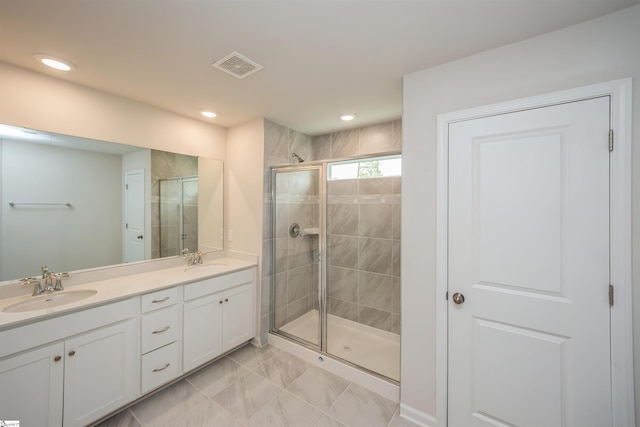 bathroom featuring tile patterned floors, walk in shower, and double vanity