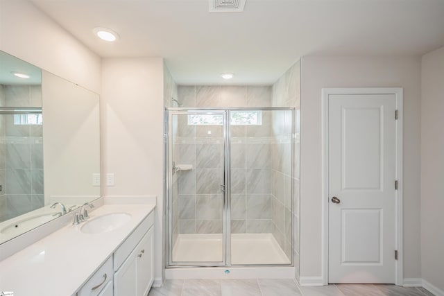 bathroom with a shower with shower door, tile patterned floors, and vanity