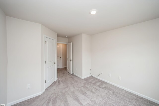 unfurnished bedroom featuring light carpet