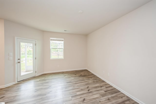 spare room featuring light hardwood / wood-style flooring and plenty of natural light