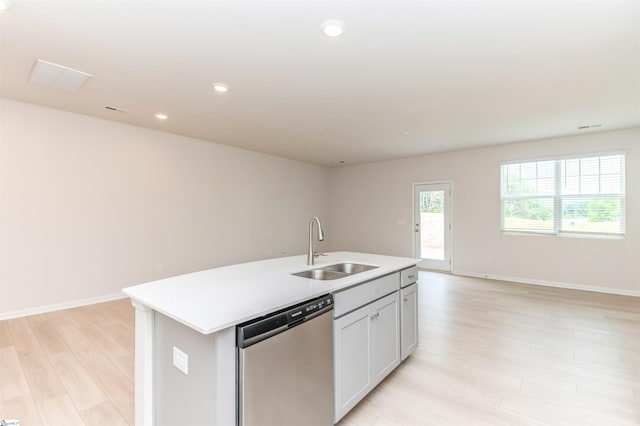 kitchen featuring a center island with sink, sink, stainless steel dishwasher, and light wood-type flooring