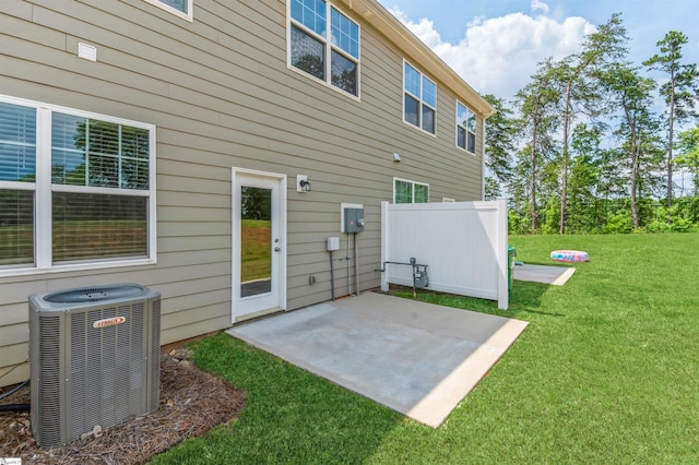 rear view of house featuring central AC unit, a patio area, and a yard