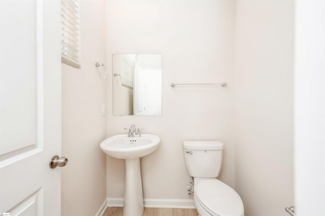 bathroom featuring toilet and wood-type flooring