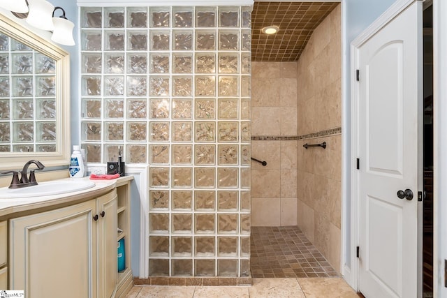 bathroom with vanity and a tile shower