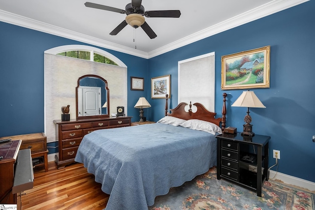 bedroom with crown molding, wood-type flooring, and ceiling fan