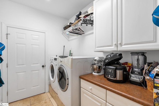 laundry room featuring cabinets, light tile patterned floors, and independent washer and dryer