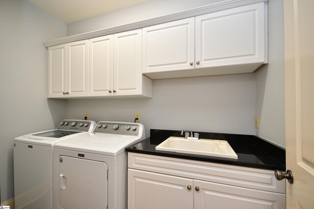 laundry area with cabinets, washing machine and dryer, and sink