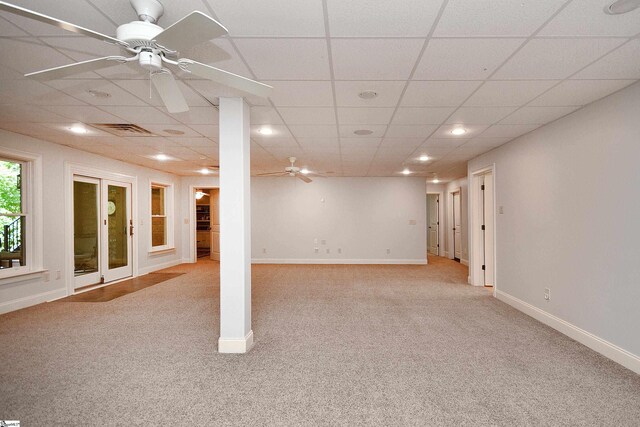 basement with ceiling fan, light colored carpet, and a paneled ceiling