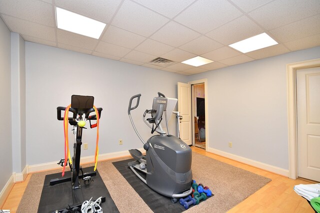 exercise area with a drop ceiling and light hardwood / wood-style floors