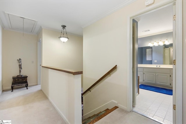 bedroom with a raised ceiling, light carpet, crown molding, ensuite bath, and ceiling fan