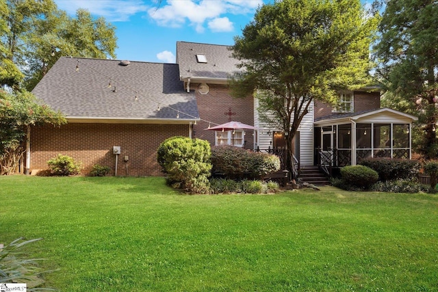 back of property with a sunroom and a yard