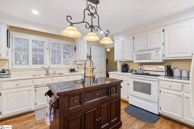 kitchen featuring white cabinetry, sink, and white appliances