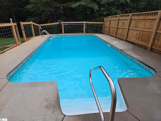 view of swimming pool featuring a fenced in pool and fence