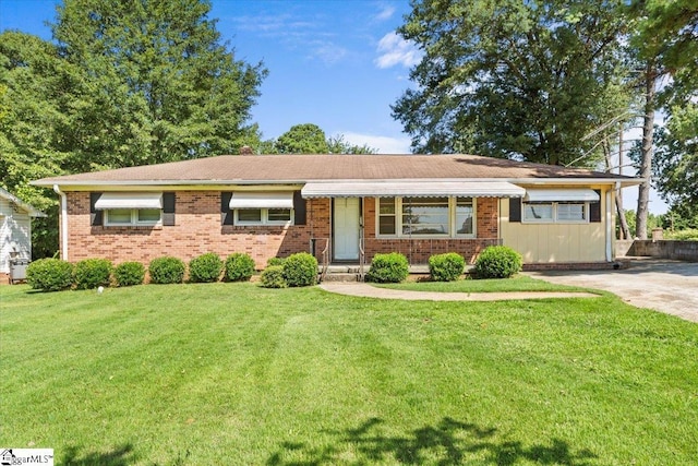 ranch-style house featuring brick siding and a front lawn