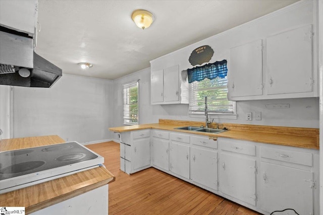 kitchen featuring light hardwood / wood-style floors, extractor fan, sink, and white cabinetry