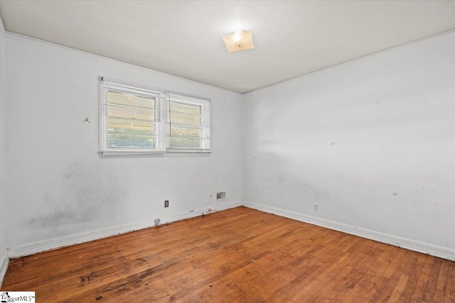 empty room with baseboards and hardwood / wood-style flooring