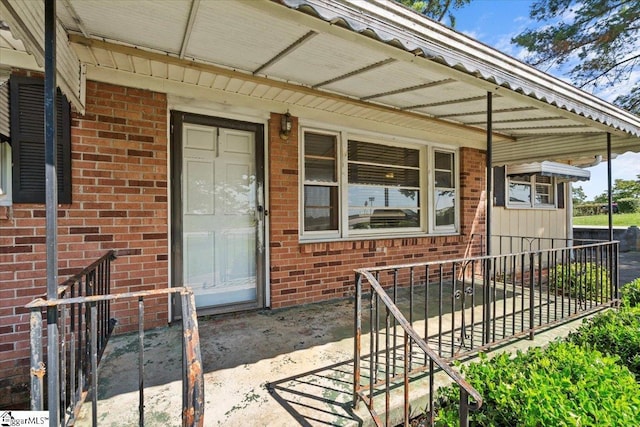 view of exterior entry featuring brick siding