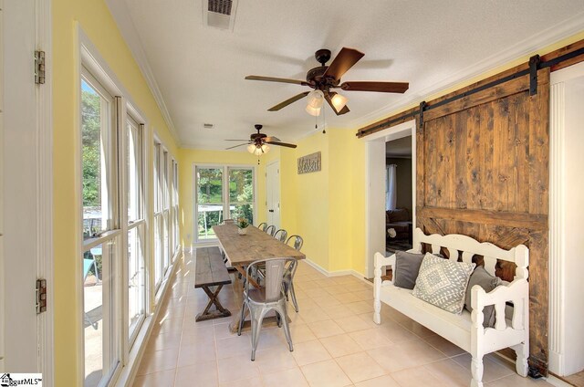 sunroom with ceiling fan and a barn door