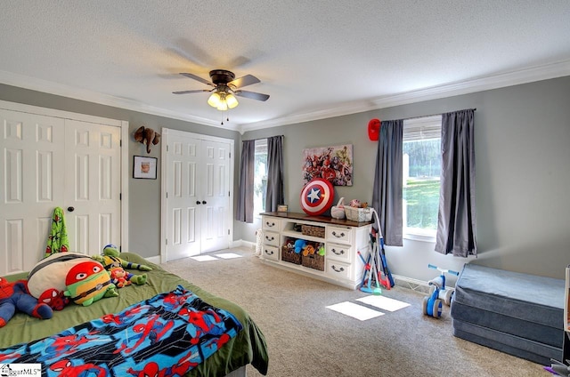 bedroom with crown molding, light colored carpet, and two closets