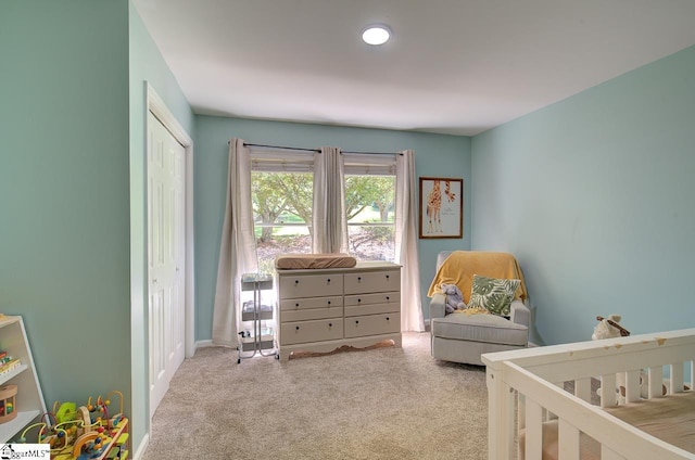 bedroom with a crib and light carpet