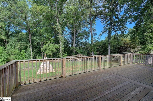 wooden terrace featuring a yard