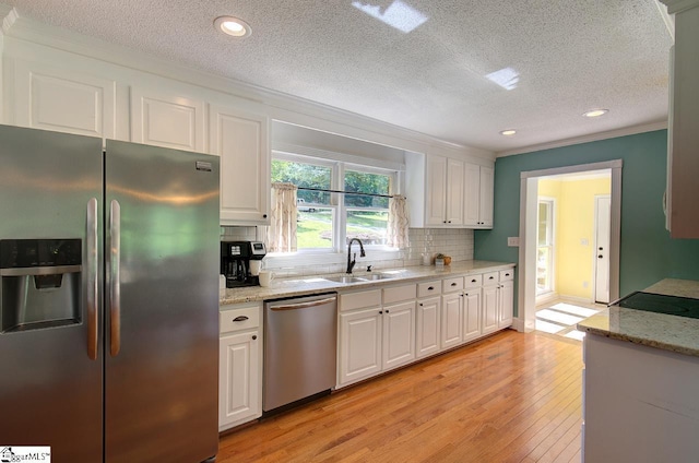 kitchen featuring sink, white cabinets, light stone countertops, and stainless steel appliances