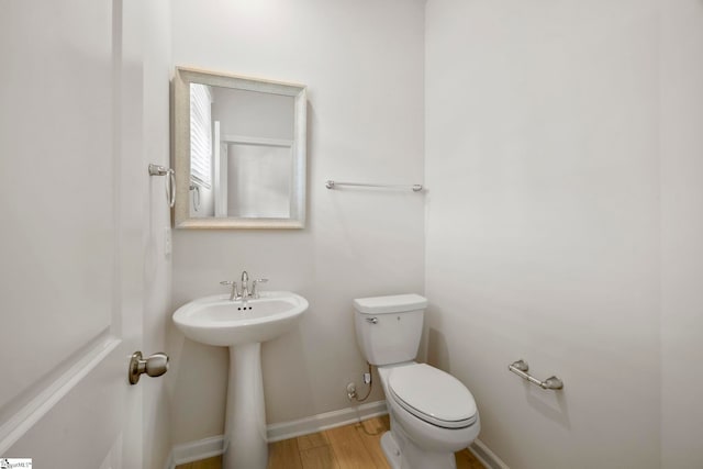 bathroom with toilet and wood-type flooring