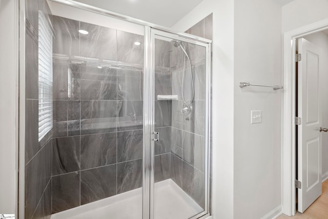 bathroom featuring a shower with door and wood-type flooring