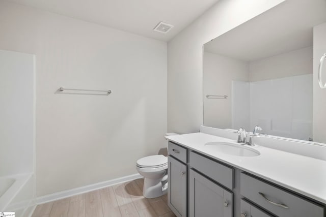 full bathroom featuring bathing tub / shower combination, toilet, vanity, and hardwood / wood-style flooring