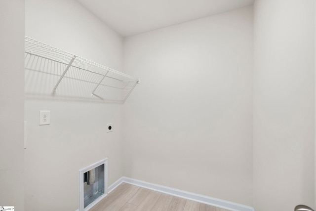 clothes washing area featuring hardwood / wood-style floors and electric dryer hookup