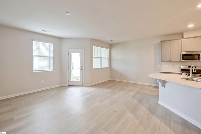 kitchen featuring light wood-type flooring, range, and decorative backsplash