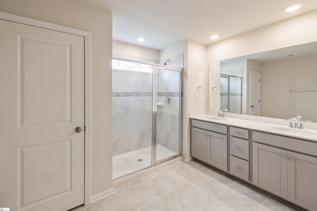 bathroom featuring tile patterned floors, double sink vanity, and walk in shower