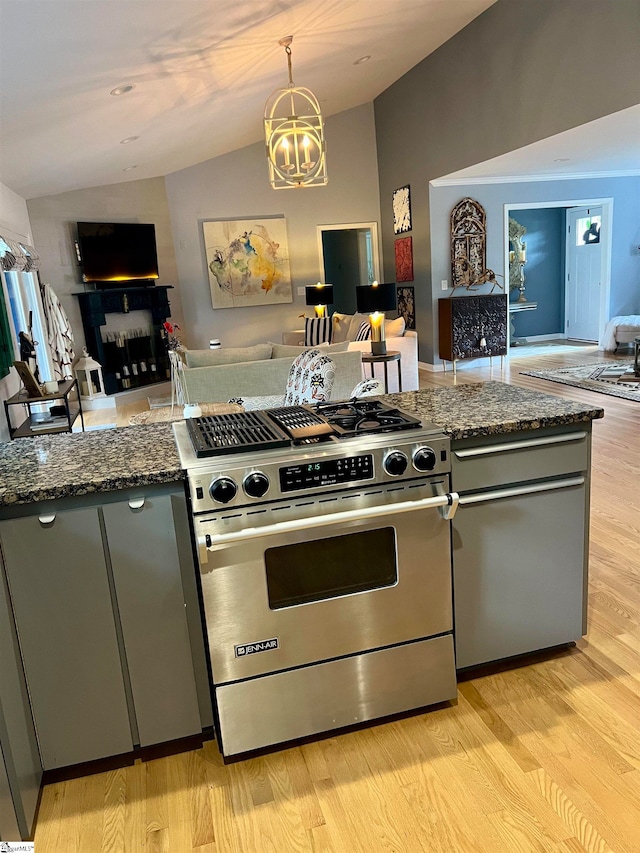 kitchen featuring light hardwood / wood-style flooring, dark stone countertops, a notable chandelier, luxury stove, and vaulted ceiling