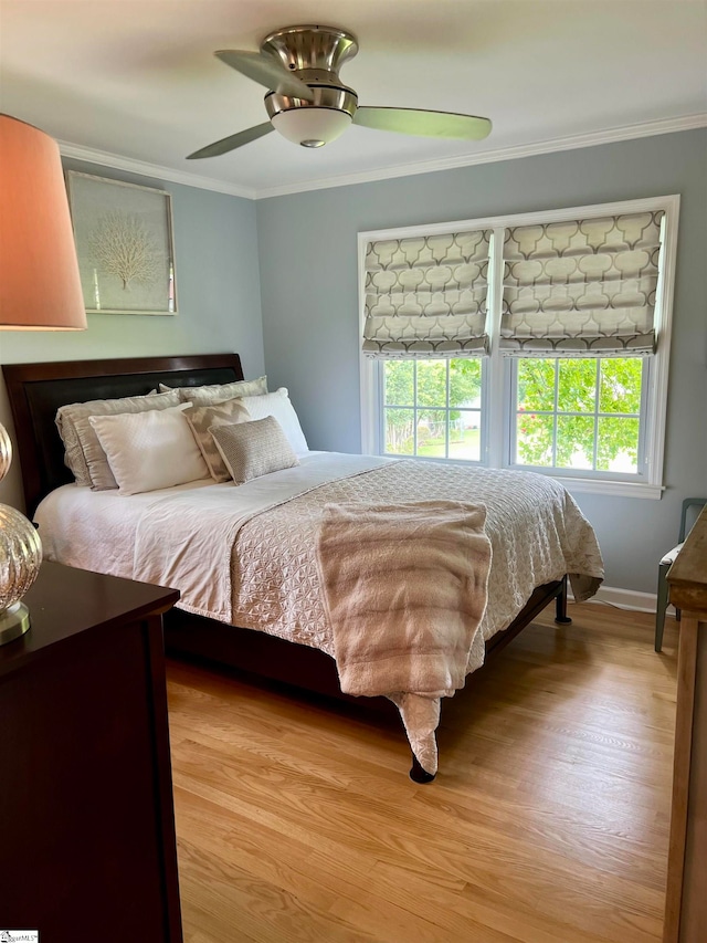 bedroom featuring ceiling fan, crown molding, and light hardwood / wood-style floors