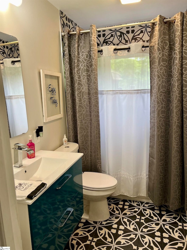 bathroom with sink, toilet, and tile patterned flooring