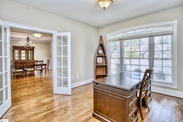 office space with a notable chandelier, french doors, and light hardwood / wood-style flooring