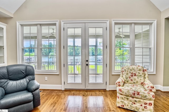 entryway with lofted ceiling, french doors, a wealth of natural light, and light hardwood / wood-style floors